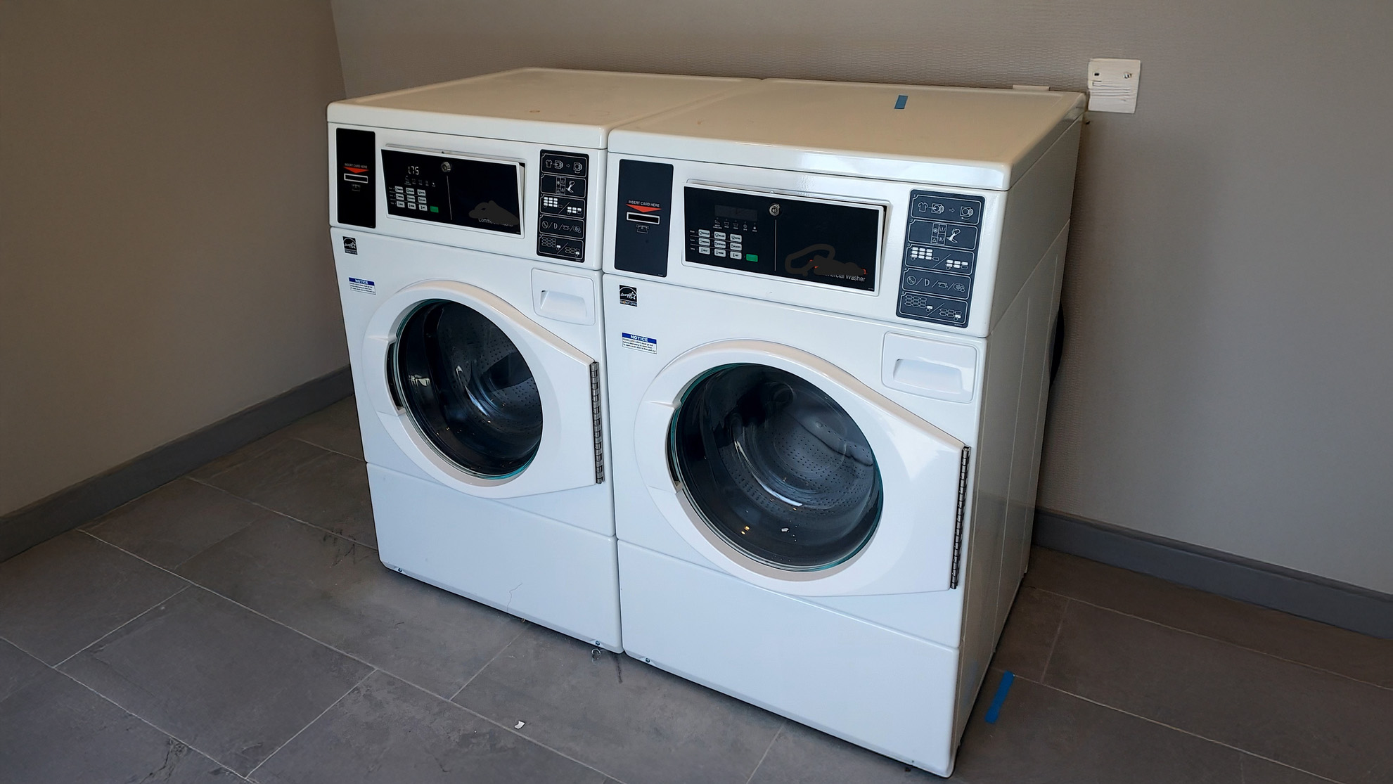 Commercial washing machines in laundry facility